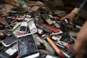 Workers sort through a pile of used mobile phones in New Delhi, India. Photographer: Kuni Takahashi/Bloomberg